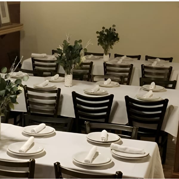 Dining room at Recess Southern Gastro Pub with multiple tables set with white tablecloths and place settings.
